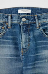 Close-up of blue jeans with a brand label on a white background