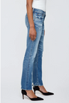 Person wearing blue jeans and black high heels on a white background
