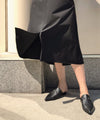 Woman wearing black leather slides from Kallmeyer