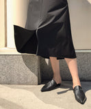 Woman wearing black leather slides from Kallmeyer
