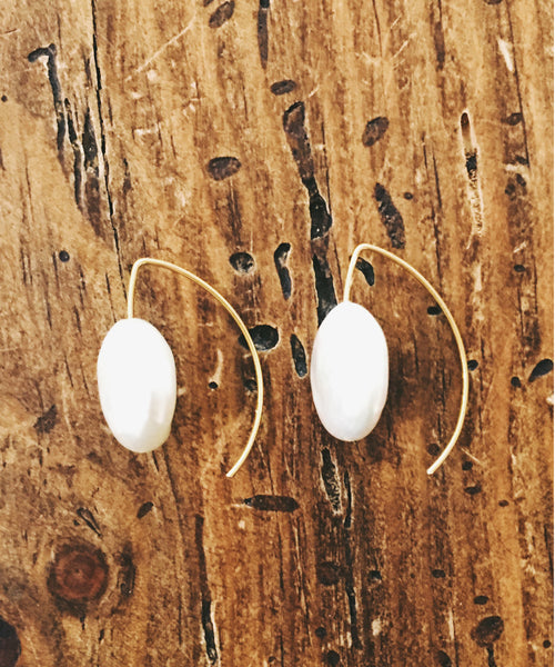 These simply elegant earrings consisting of a single button pearl floating on a wire.