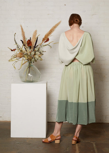 Twist back top in green with skirt viewed from rear