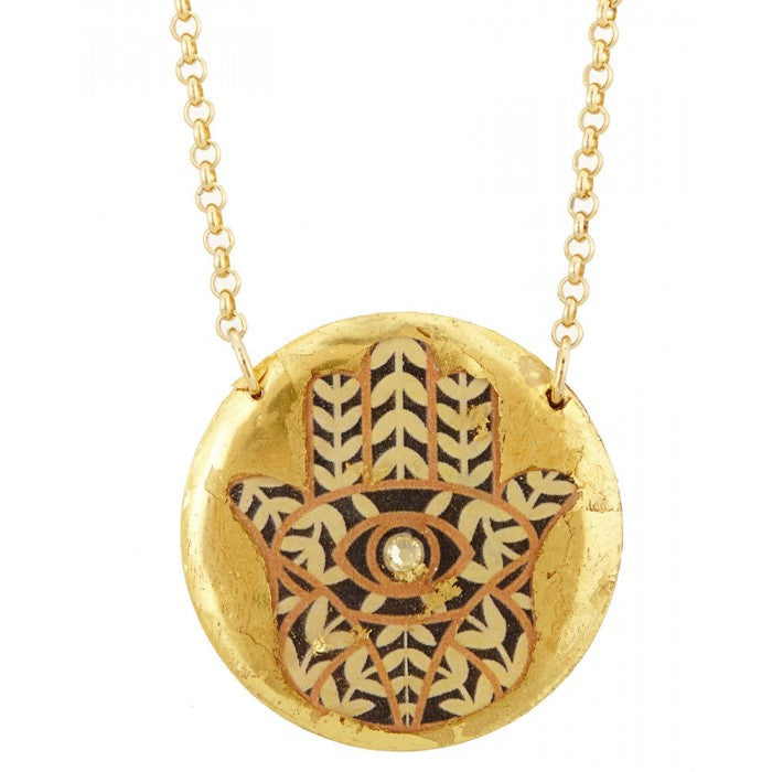 Beautiful Evocateur gold leaf pendant on a 17" chain, adorned with Hamsa, available at Patricia in Southern Pines, NC